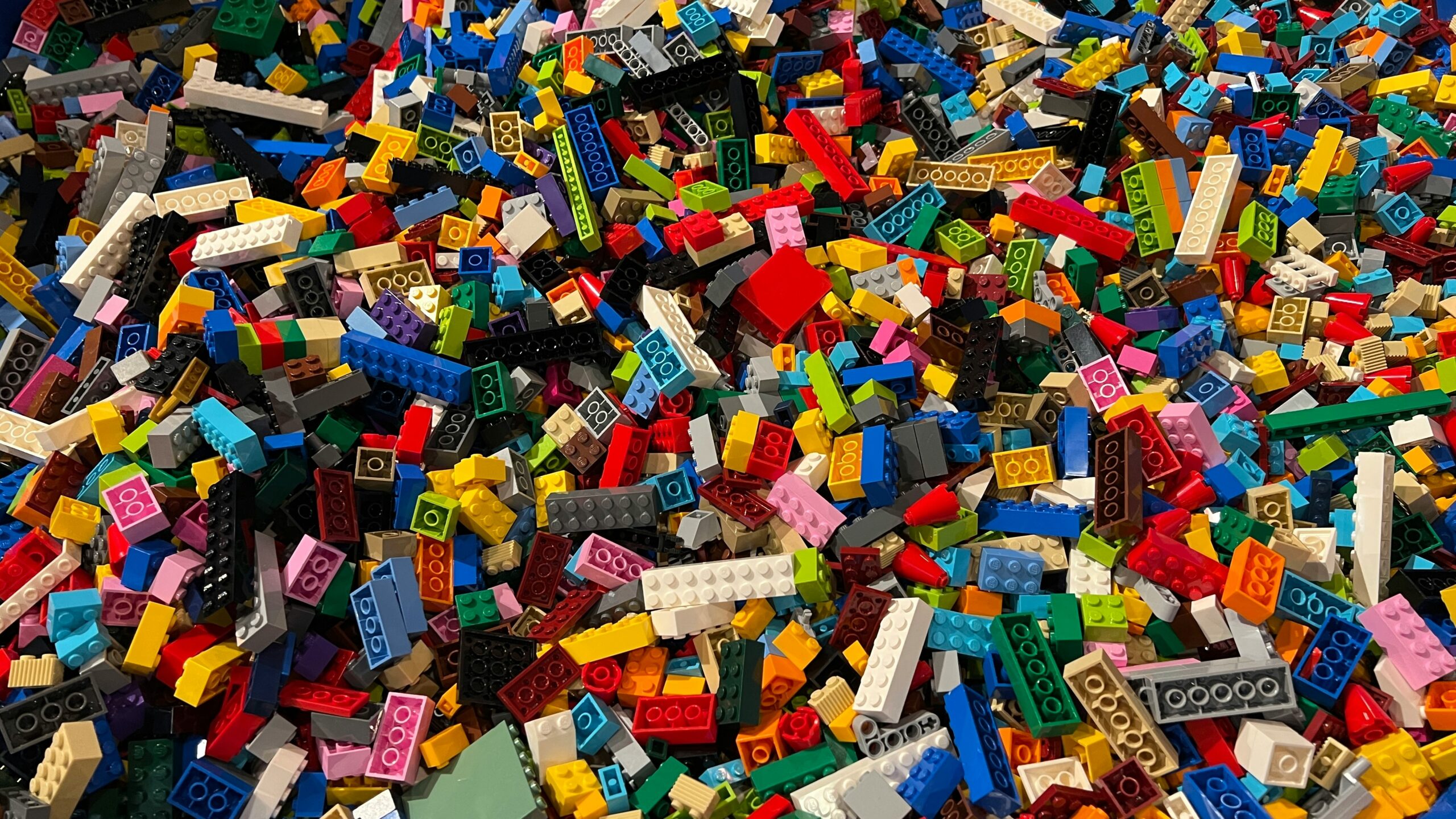 Large assortment of mixed LEGO bricks in many colors piled together