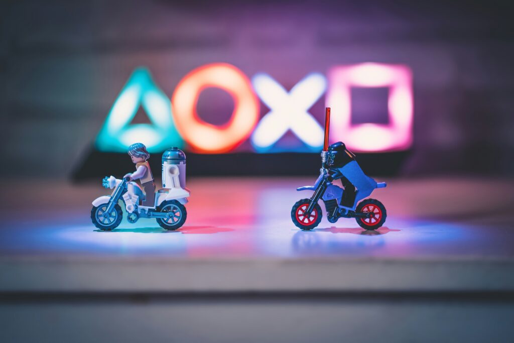 LEGO Star Wars minifigures riding motorcycles with illuminated PlayStation controller symbols in the background